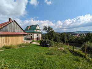 an old house and a barn with a yard at Pod Lubogoszczem in Mszana Dolna
