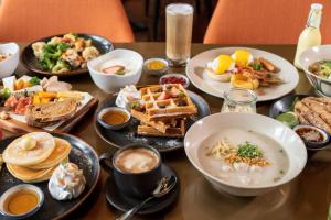 une table recouverte de assiettes et de bols de nourriture dans l'établissement Hotel Indigo Bangkok Wireless Road, an IHG Hotel, à Bangkok
