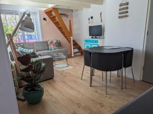 een woonkamer met een tafel en een bank bij Casa Koopboom in Egmond aan Zee
