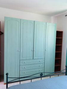 a bedroom with blue cabinets and a bed at Valledoria Residenza sole e mare in Codaruina