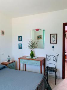 a bedroom with a bed and a desk and a chair at Valledoria Residenza sole e mare in Codaruina