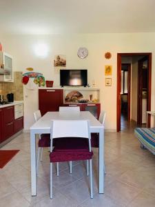 einen weißen Tisch und Stühle in der Küche in der Unterkunft Valledoria Residenza sole e mare in Codaruina