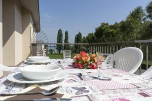 シルミオーネにあるAppartamenti Residence Tulipanoのバルコニーにテーブルと花