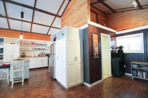 une grande cuisine avec des armoires blanches et un réfrigérateur dans l'établissement Le Duc on the Lake - Cozy waterfront Cottage, à Saint-André-Avellin