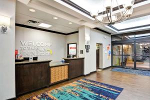 a lobby with a welcome to the six senses sign on the wall at Hampton Inn & Suites Boynton Beach in Boynton Beach