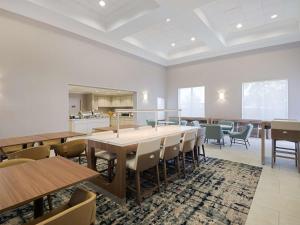 Homewood Suites by Hilton Columbia, SC في كولومبيا: غرفة طعام مع طاولات وكراسي ومطبخ