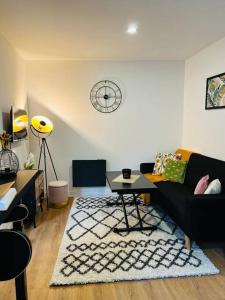 a living room with a black couch and a rug at Black Pearl V in Amiens