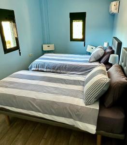 uma cama grande num quarto com paredes azuis em Casa-De-Golf em Alhaurín de la Torre