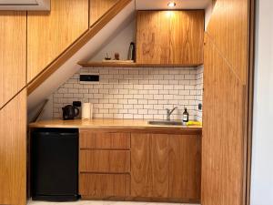 una cocina con armarios de madera y fregadero en Premiun Apart 1 - Pleno Centro en Suipacha