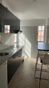 a kitchen with a sink and a chair in it at Hostel da Praia in Portimão