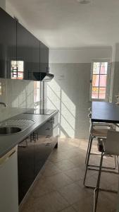 a kitchen with a sink and a chair in it at Hostel da Praia in Portimão +28 photos