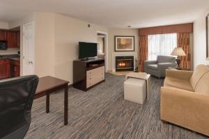 a living room with a couch and a tv at Homewood Suites by Hilton Chicago - Schaumburg in Schaumburg