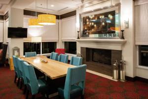 a dining room with a table and chairs and a fireplace at Hilton Garden Inn Columbus/Dublin in Dublin
