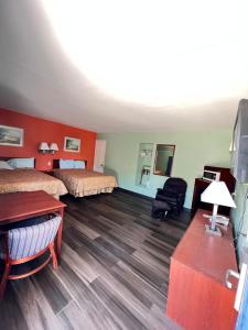 a hotel room with two beds and a desk at Town & Country Motel in Sioux City