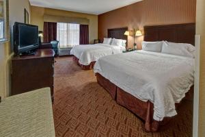 a hotel room with two beds and a flat screen tv at Hampton Inn & Suites Corsicana in Corsicana