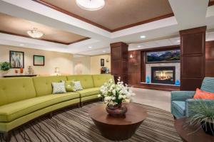 sala de estar con sofá verde y chimenea en Homewood Suites by Hilton Denver - Littleton, en Littleton