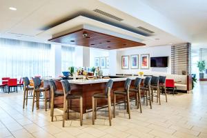 a large kitchen with a bar with chairs around it at Hilton Garden Inn Alexandria Old Town National Harbor in Alexandria