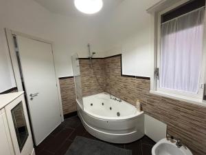 a bathroom with a large tub and a toilet at Camera relax riservata intero appartamento in Carini