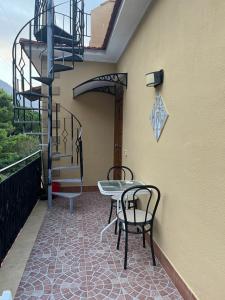 a patio with two chairs and a table and a spiral staircase at Camera relax riservata intero appartamento in Carini +1 photo