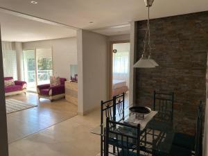 a kitchen and living room with a table and chairs at Prestigia Golf city Bouskoura Apartment in Bouskoura