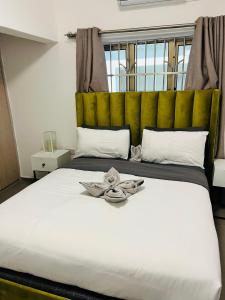 LetlhakaweにあるLetsibogo Executive Apartmentsのベッドルーム(黄色のヘッドボード付きの大きな白いベッド1台付)