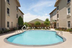 a swimming pool in a courtyard with two buildings at Hampton Inn and Suites Springdale in Springdale