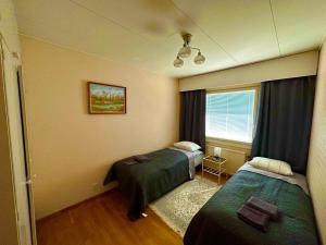 um quarto de hotel com duas camas e uma janela em Miramar Mariehamn Åland em Mariehamn