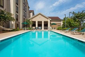 a swimming pool with chairs and a building at Hampton Inn & Suites Greenville/Spartanburg I-85 in Duncan