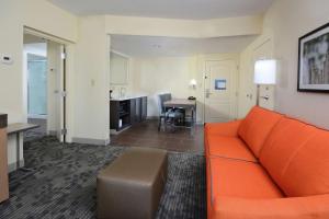 a living room with an orange couch and a kitchen at Hampton Inn & Suites Greenville/Spartanburg I-85 in Duncan