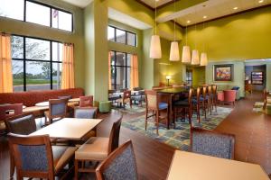 a restaurant with tables and chairs and windows at Hampton Inn and Suites Lynchburg in Lynchburg