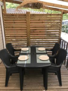une table noire et quatre chaises sur la terrasse dans l'établissement Chaussy55, à Lagorce