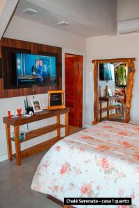 - une chambre avec un lit, un bureau et une télévision dans l'établissement Recanto Vera Lucia, à Santo Amaro da Imperatriz