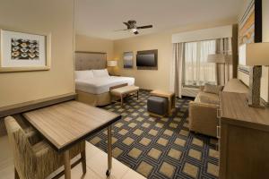 a hotel room with a bed and a living room at Homewood Suites by Hilton Midland in Midland