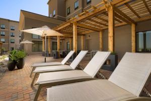 a row of chairs and umbrellas on a patio at Homewood Suites by Hilton Midland in Midland