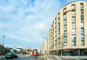 een gebouw in een stadsstraat met een bus bij Hampton by Hilton London Waterloo in Londen