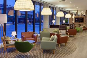 un vestíbulo con sillas, mesas y ventanas en Hampton by Hilton London Waterloo, en Londres