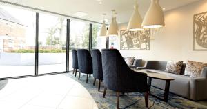 DoubleTree by Hilton Chester في تشيستر: غرفة انتظار مع كراسي وطاولة وأريكة