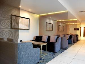 una sala de espera con sofás, mesa y sillas en DoubleTree by Hilton Chester, en Chester