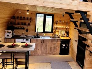 a kitchen in a log cabin with a table and chairs at MTISGULI Cottages in Kazbegi