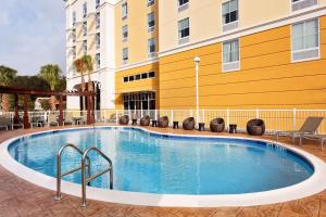 Hampton Inn & Suites Orlando North Altamonte Springs في أورلاندو: مسبح في فندق فيه كراسي ومبنى
