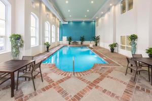 einen Pool in einem Zimmer mit Tischen und Stühlen in der Unterkunft Homewood Suites by Hilton New Orleans in New Orleans