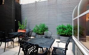 an outdoor patio with tables and chairs and plants at Hampton Inn Madison Square Garden in New York