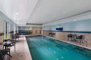 een zwembad in een hotelkamer met stoelen en tafels bij Hampton Inn & Suites Wilmington Christiana in Newark
