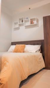 una camera da letto con un letto con pareti bianche e scaffali di Bulacan Staycation by Mags@ SMDC Cheer Residences a Marilao