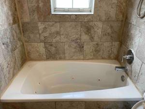 eine Badewanne im Bad mit Fenster in der Unterkunft Derby City Getaway in Louisville