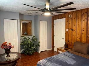 een woonkamer met een bed en een plafondventilator bij Derby City Getaway in Louisville