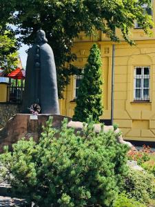 a statue in front of a yellow building at Apartman Tapolca Belváros in Tapolca