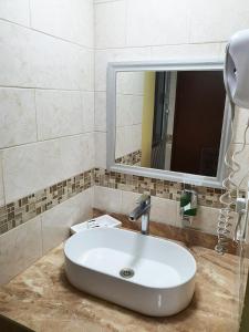 W łazience znajduje się umywalka i lustro. w obiekcie Hotel Marques de Cima w mieście Nogales