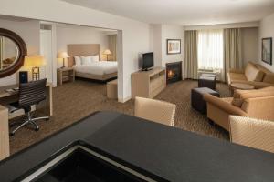um quarto de hotel com uma cama e uma sala de estar em DoubleTree by Hilton Portland Tigard em Tigard
