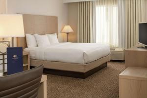 ein Hotelzimmer mit einem Bett und einem TV in der Unterkunft DoubleTree by Hilton Portland Tigard in Tigard